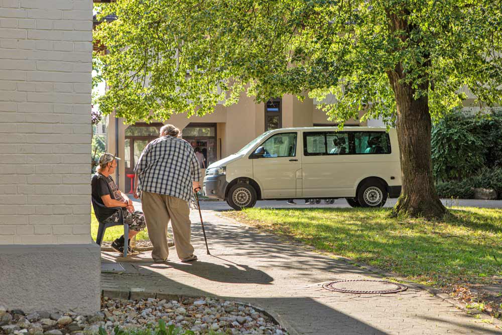 Betreute Personen an Hauswand im Dornahof Gel&auml;nde
