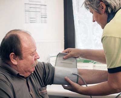 älterem Herrn wird der Blutdruck gemessen