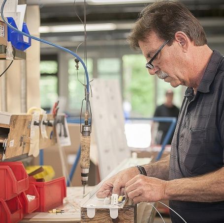 Tagestrukturierte HIlfe - Mann bei Lampenmotnage in der Werkstatt